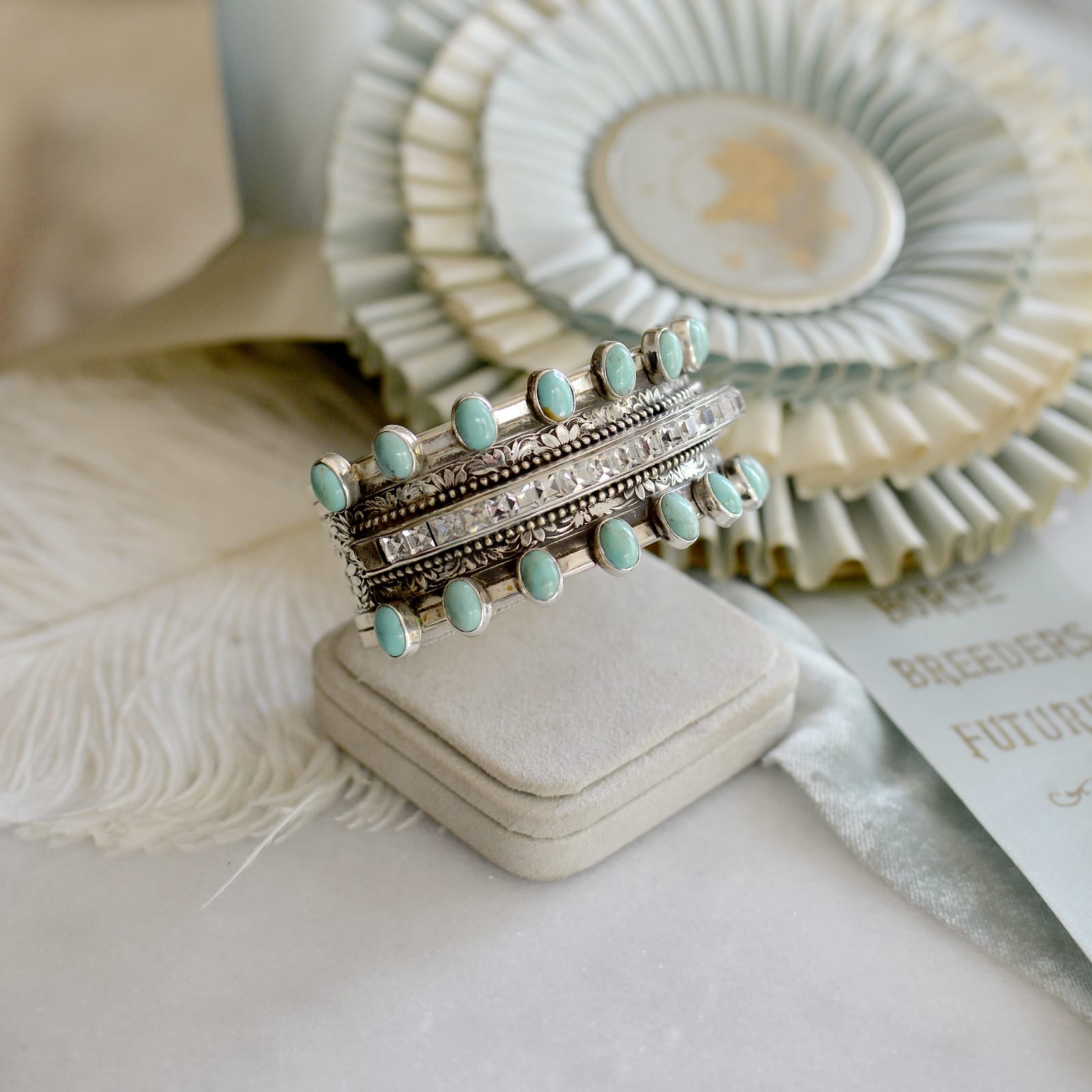 Jill Garber, An outstanding hand pressed floral cuff bracelet with divine early 20 th. Century French paste center framed on either side with natural kingman turquoise cabochons