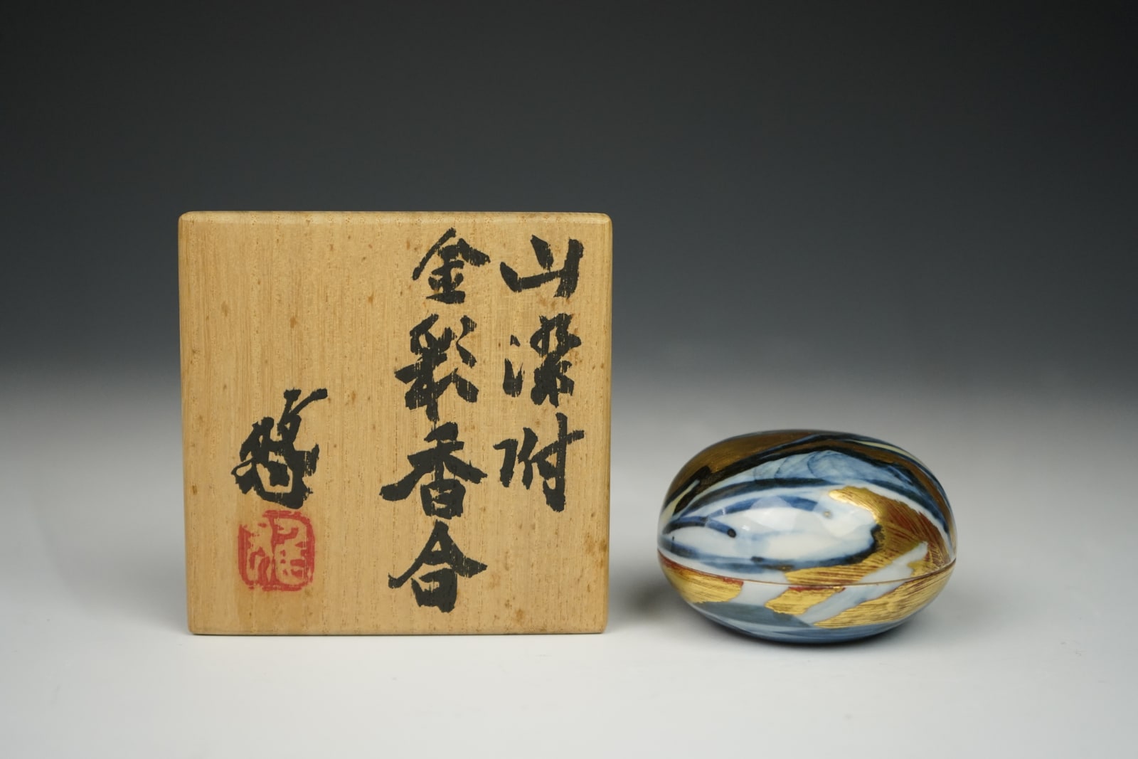 Kondo Yuzo 近藤悠三, Blue and White Box with Gold Overglaze showing a Mountain Range Scene 山染付金彩香合, 1980's