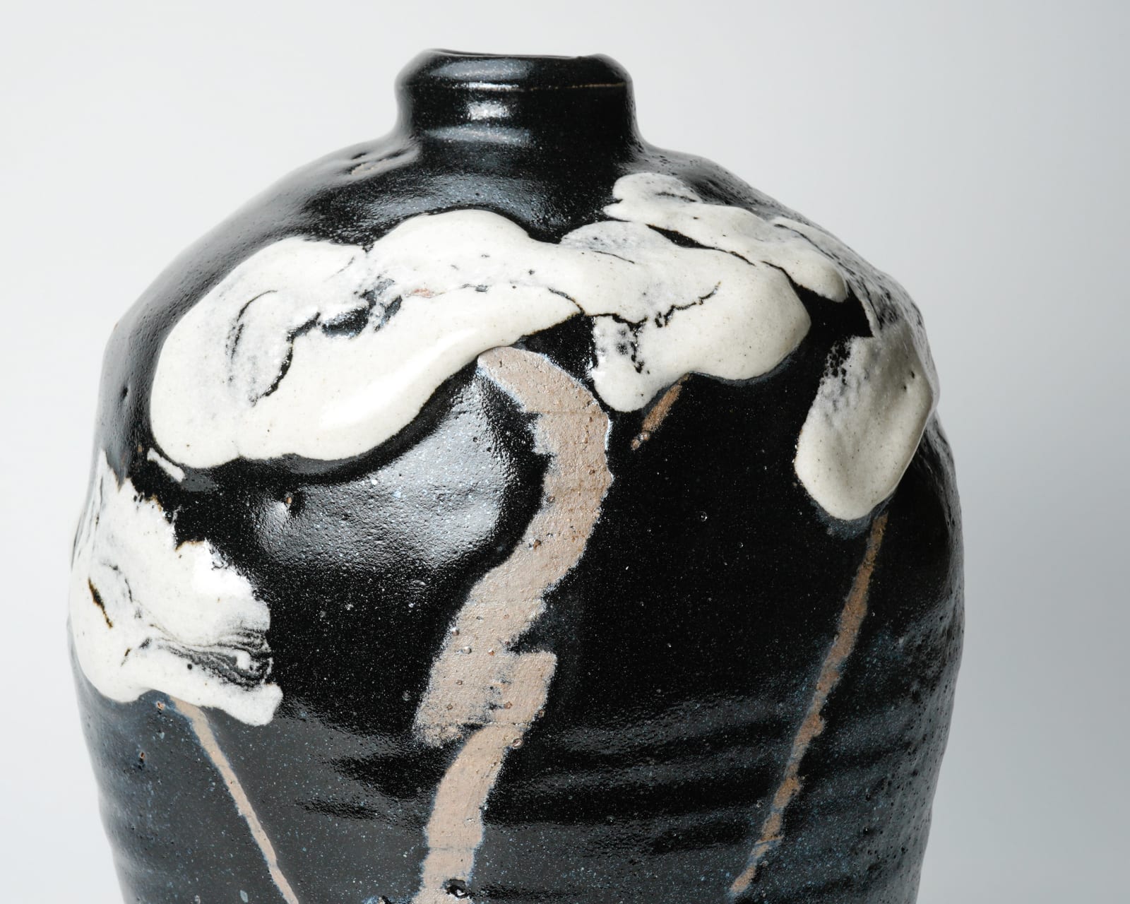 Shimizu Uichi 清水 卯一, Flat jar with white glaze on gloss iron glaze 鉄耀白流扁壺