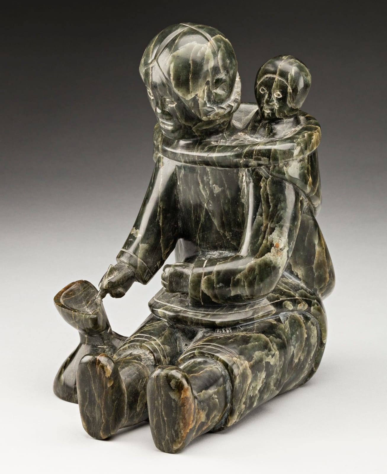 MANNUMI SHAQU (1917-2000) KINNGAIT (CAPE DORSET), Mother and Child, Tending a Qulliq, c. 1953-54