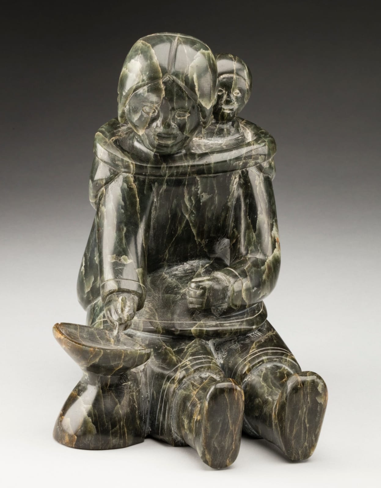 MANNUMI SHAQU (1917-2000) KINNGAIT (CAPE DORSET), Mother and Child, Tending a Qulliq, c. 1953-54