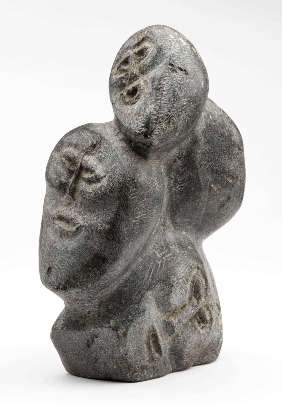 JOHN TIKTAK, R.C.A. (1916-1981) KANGIQLINIQ (RANKIN INLET), Heads Emerging from Stone, c. 1967