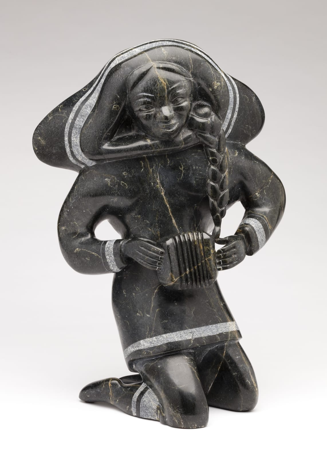 OSUITOK IPEELEE, R.C.A. (1922 or 1923-2005) KINNGAIT (CAPE DORSET, Young Woman Playing a Concertina, early 1980s