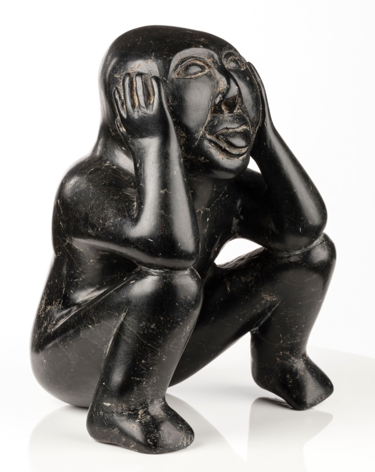 EEGYVUDLUK POOTOOGOOK (1931-1999) KINNGAIT (CAPE DORSET), Seated Man Sticking Out his Tongue, c. early 1960s