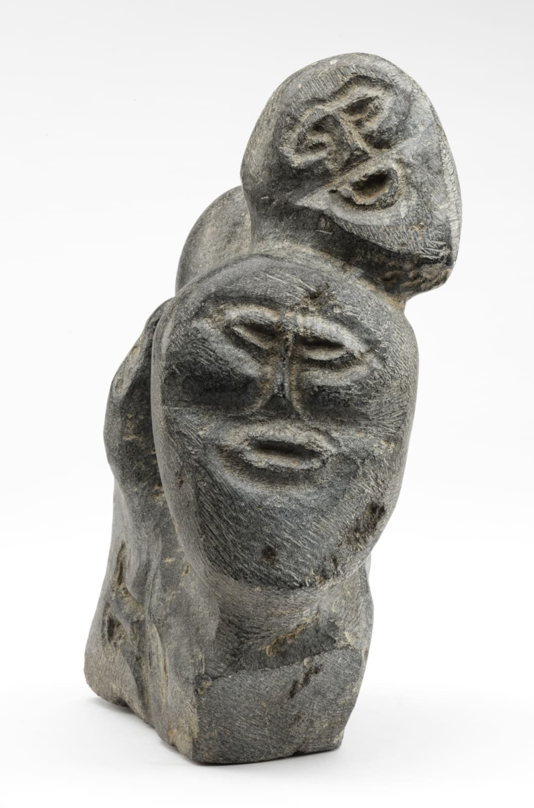 JOHN TIKTAK, R.C.A. (1916-1981) KANGIQLINIQ (RANKIN INLET), Heads Emerging from Stone, c. 1967