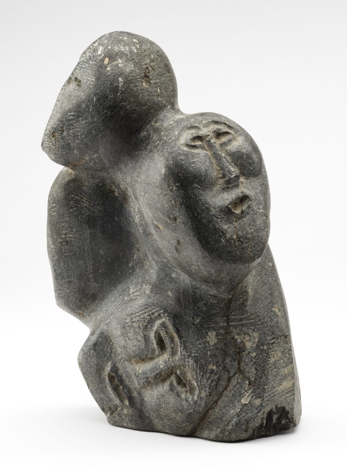 JOHN TIKTAK, R.C.A. (1916-1981) KANGIQLINIQ (RANKIN INLET), Heads Emerging from Stone, c. 1967