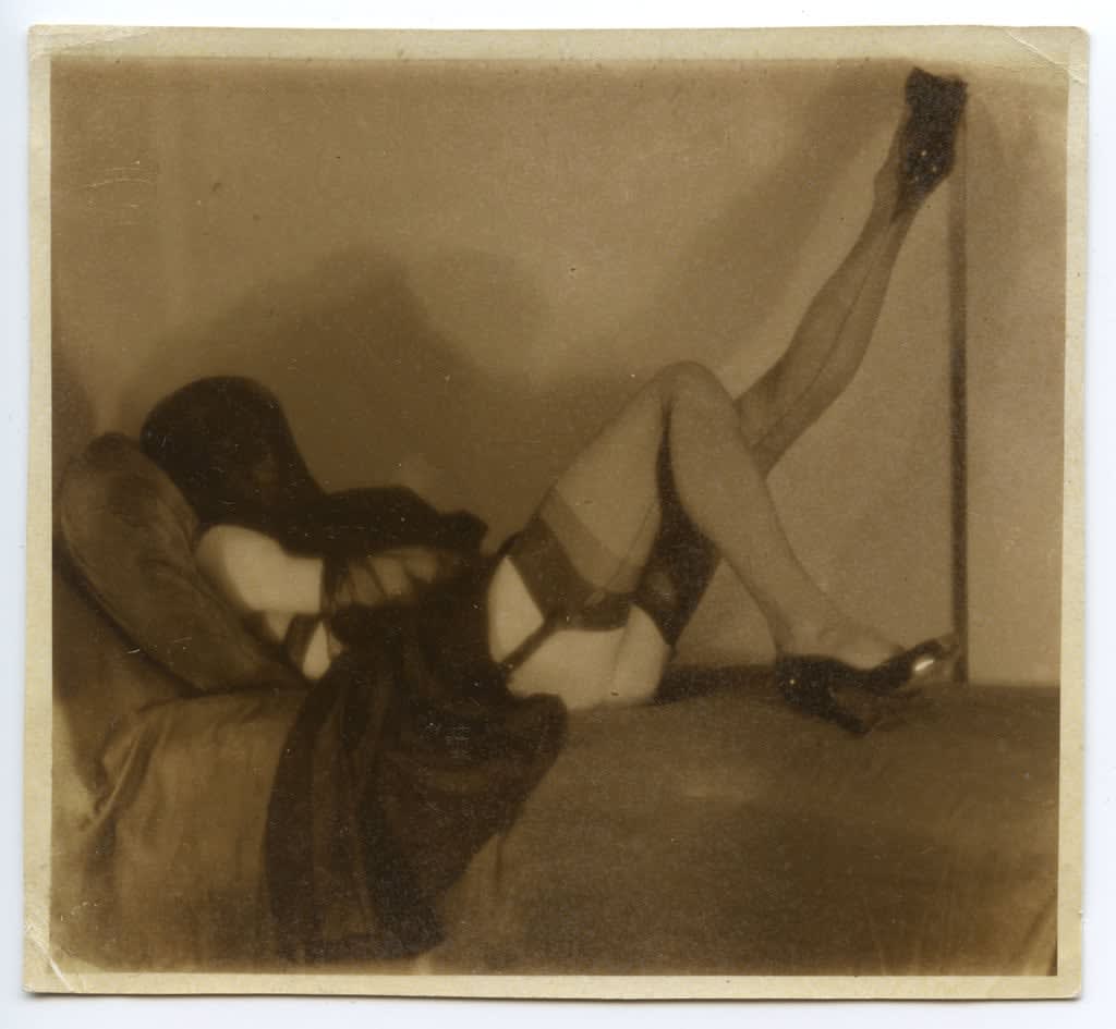 Pierre Molinier, Autoportrait couché, visage voilé, jambe gauche levée, 1955