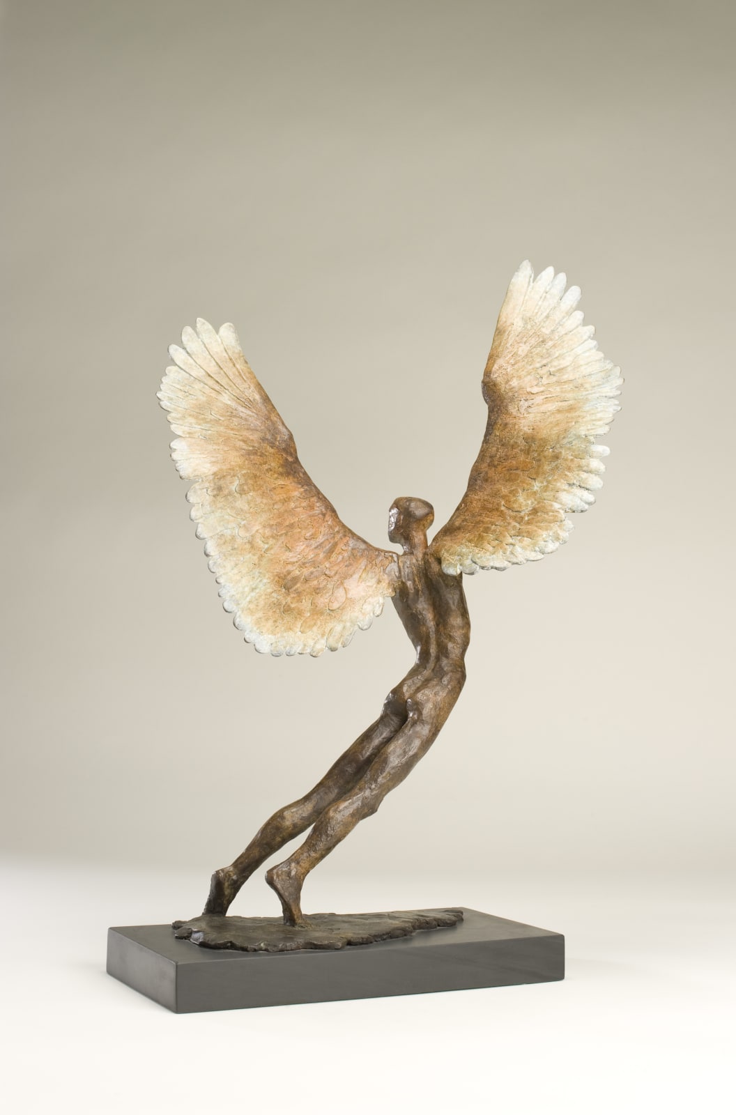 Figurative bronze sculpture of mythical Greek winged figure Icarus by Nicola Godden, displayed on plinth.
