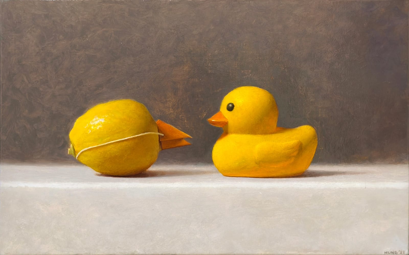 Lemon with paper beak faces a rubber duck