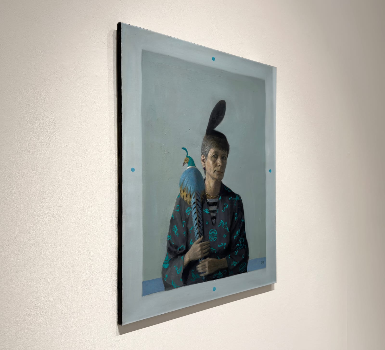 Woman sitting with blue and yellow pheasant on shoulder