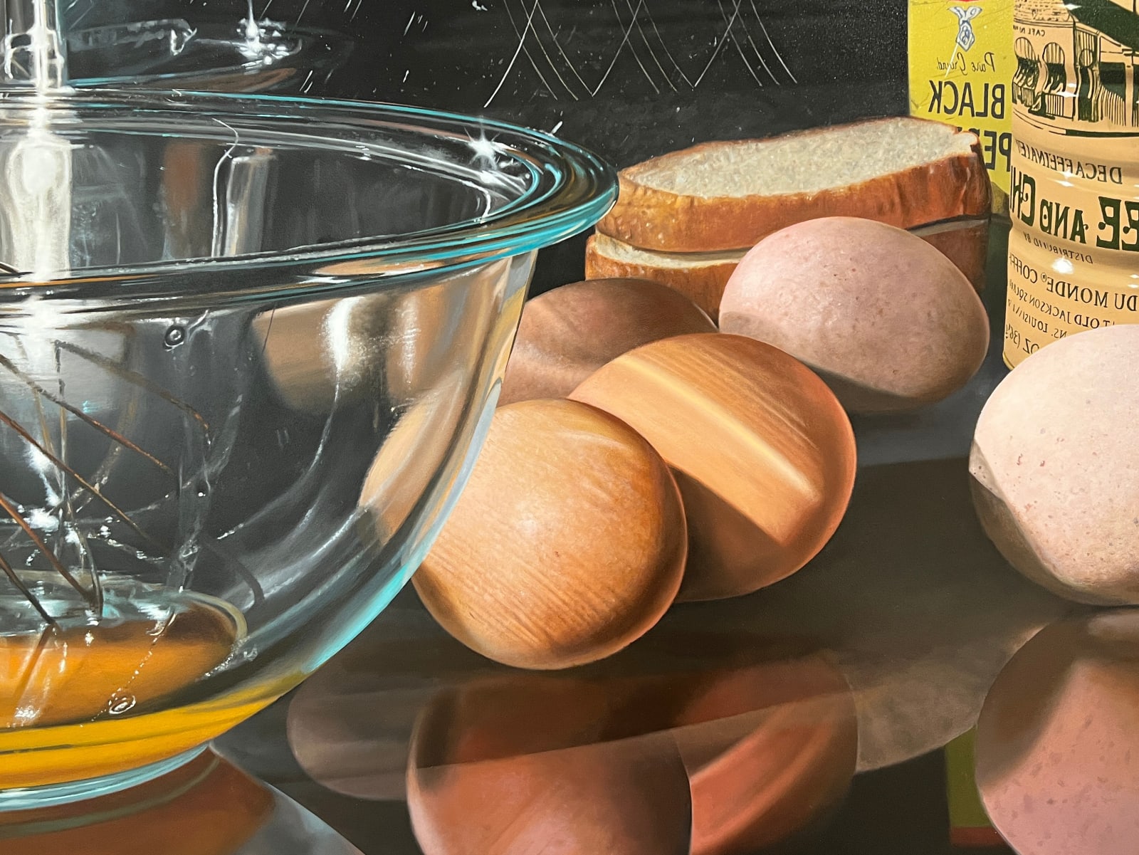 Bowl with whisk and broken eggs alongside 4 whole eggs and coffee tin