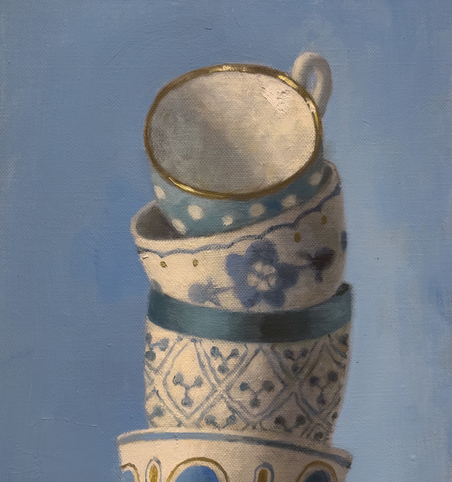 painted stack of tea cups on blue background