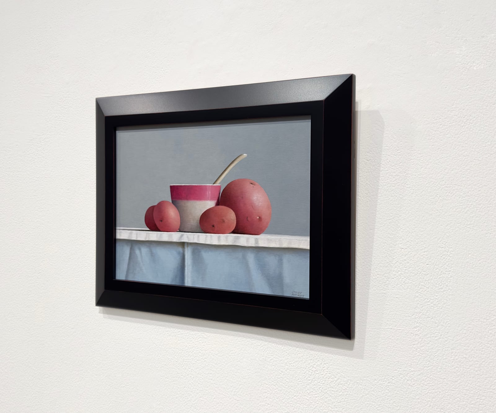 Still life painting of a cup with potatoes