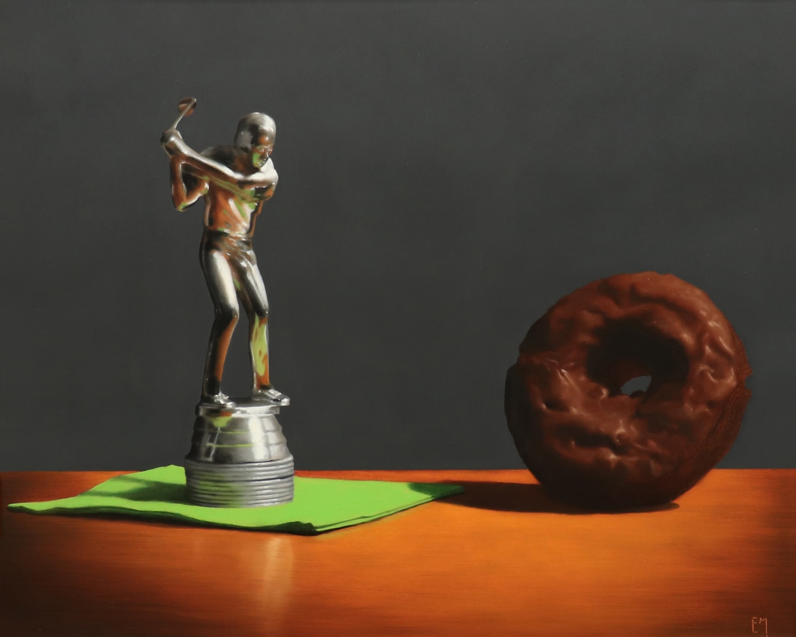 Silver golf trophy on green napkin in swing towards chocolate covered donut