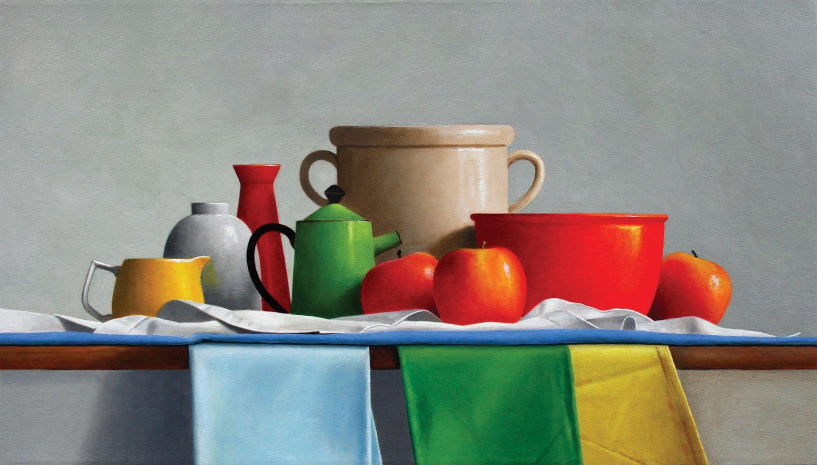 Kettles, bowls, and apples organized on blue green and yellow cloths