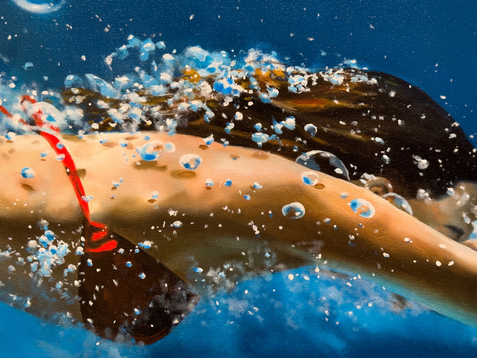 Woman in a red bikini diving through blue water