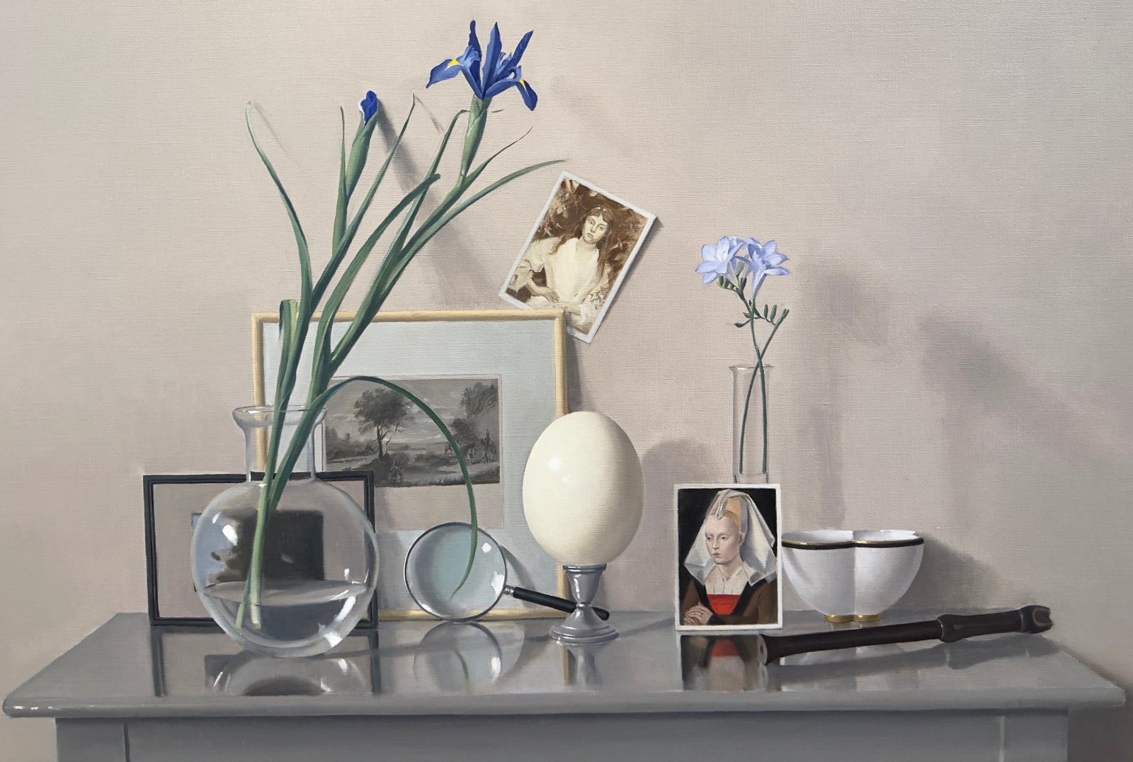 Still life with a table and an ostrich egg, photographs, and plants