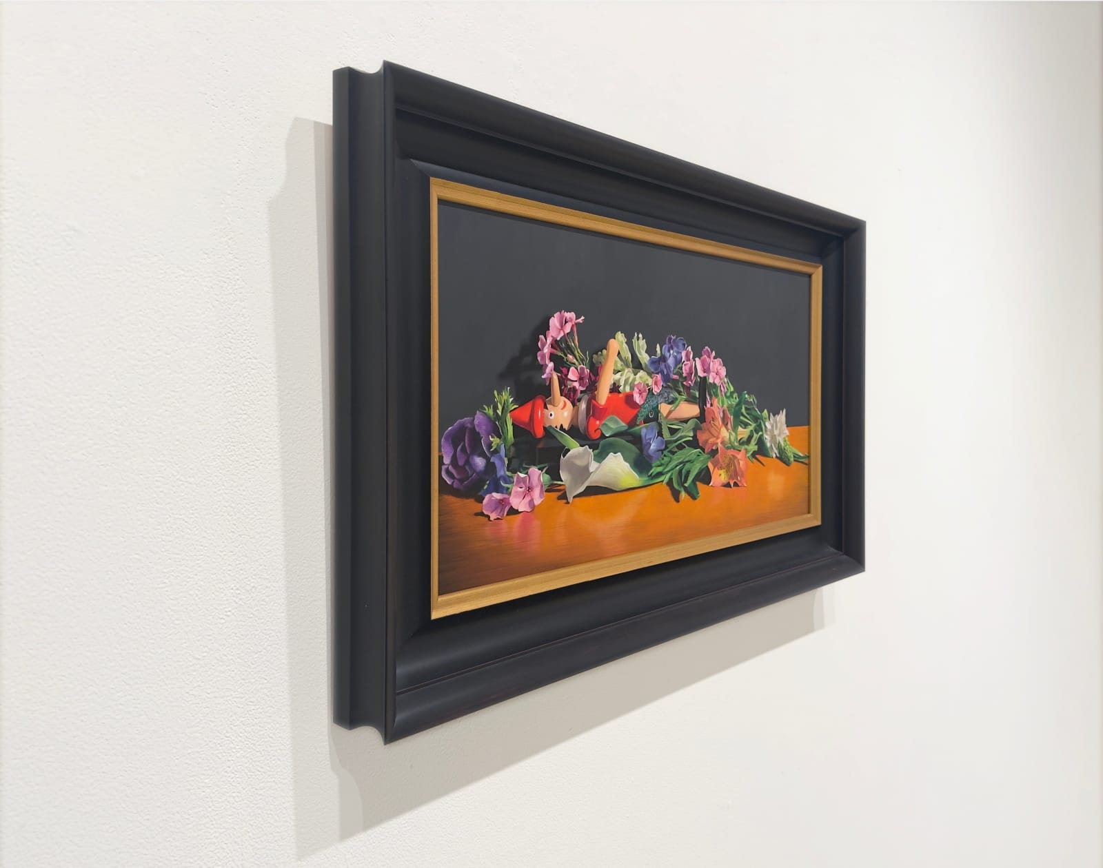 Still life painting of a Pinocchio doll under flowers