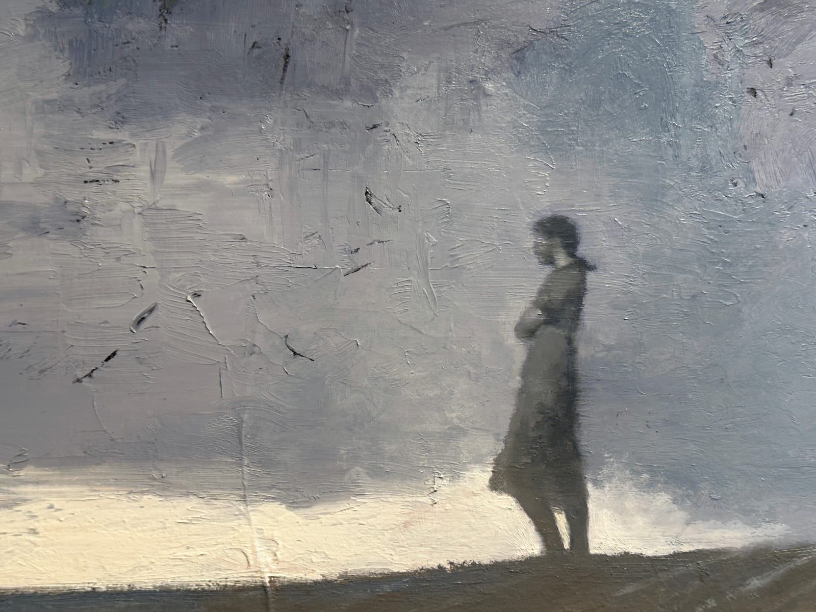 Little boy sitting facing away from us as he looks into the distance at a woman; broken toy planes are behind him.