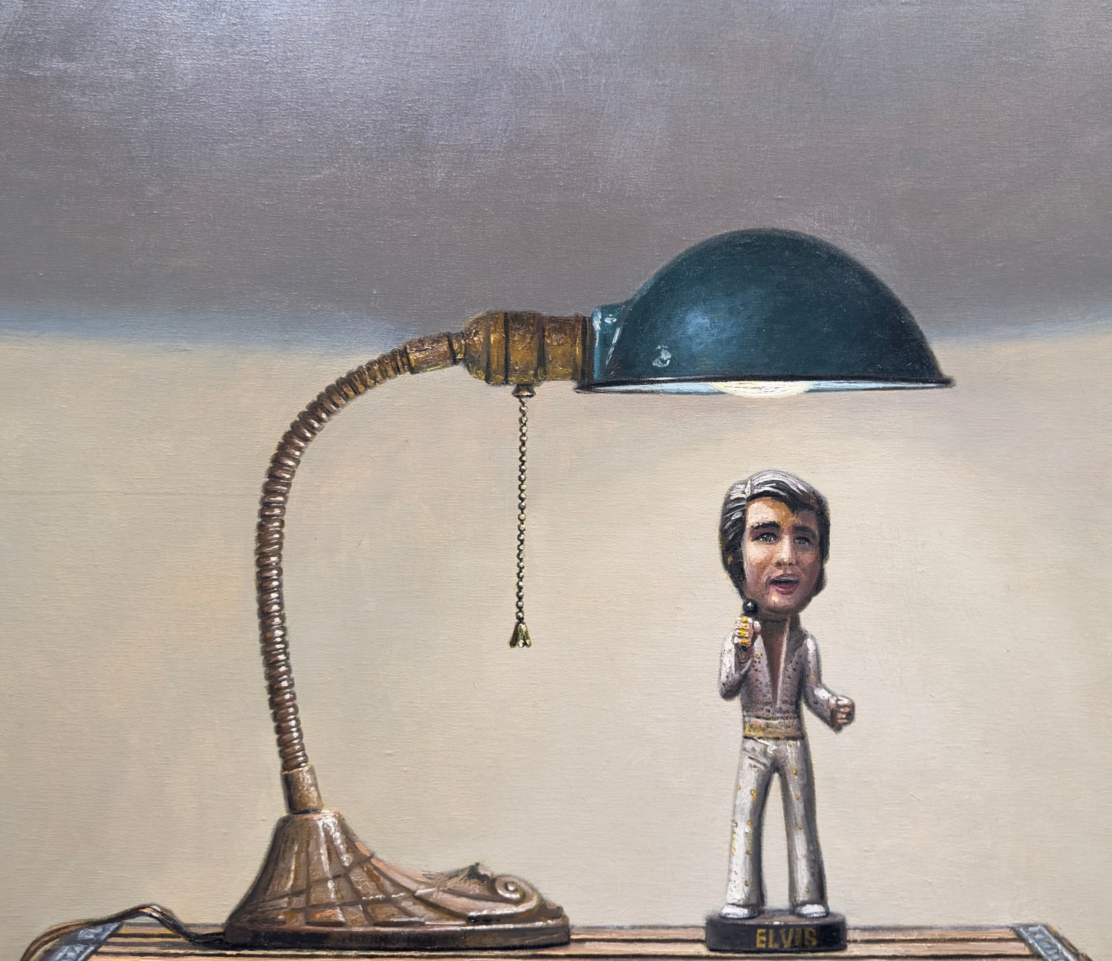 Painting of an Elvis figurine on top of a box with a desk lamp