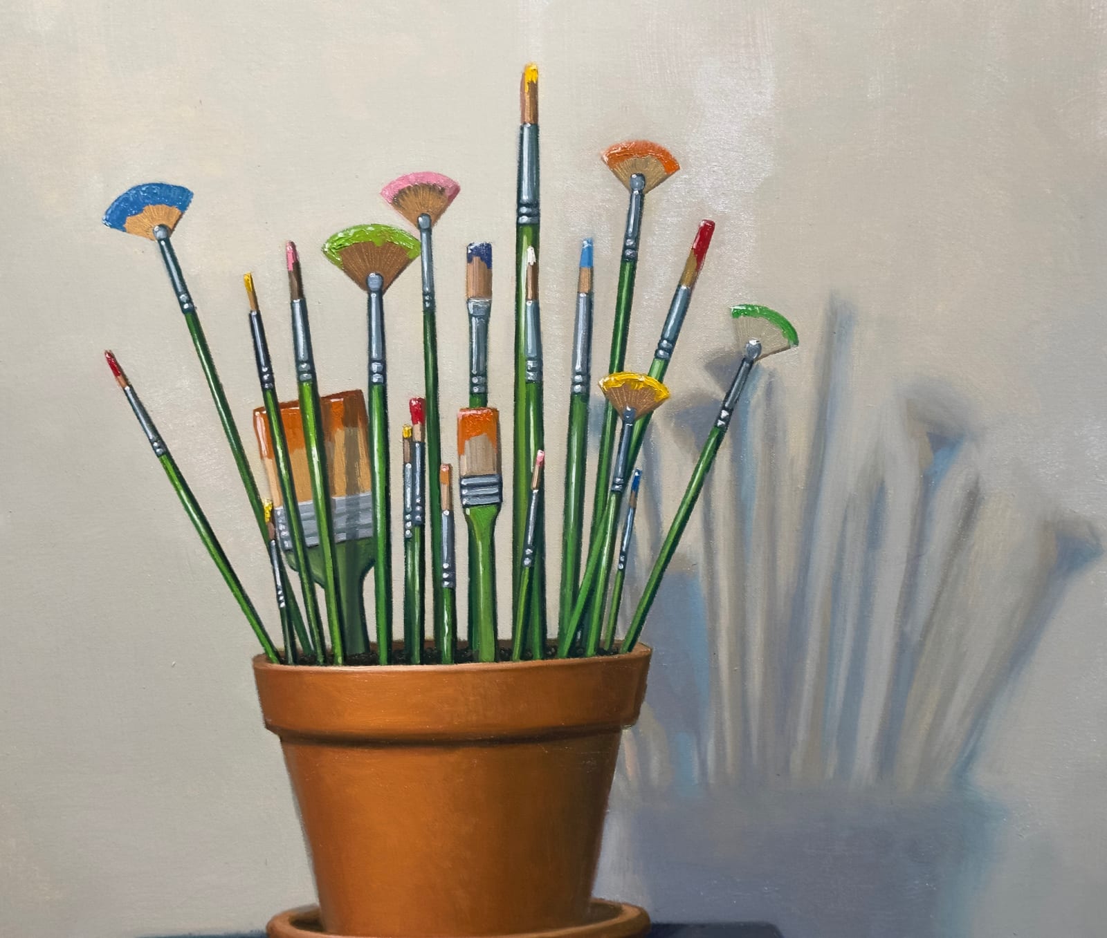 Still life painting of a flowerpot with paint brushes in it atop a stack of books