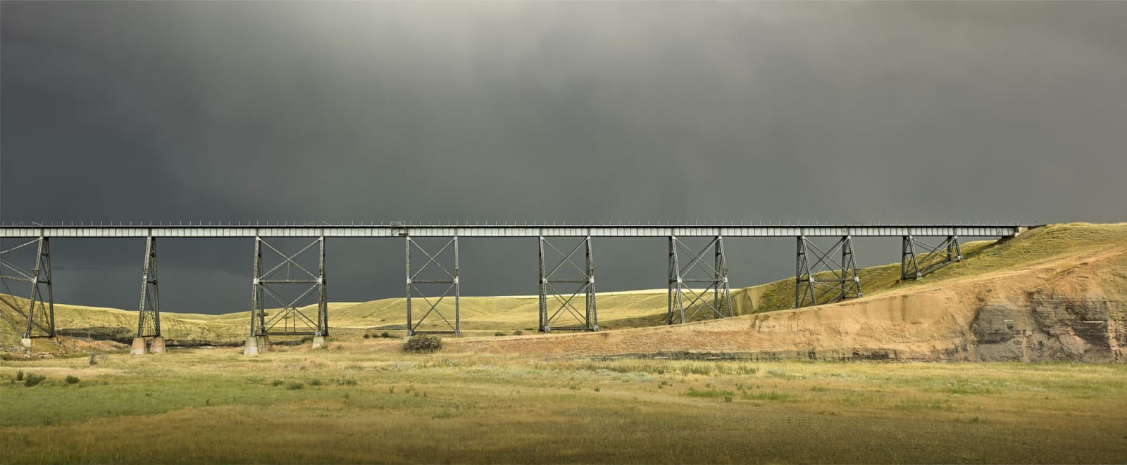 Jim Westphalen horizontal piece stormy sky, trestle bridge, green field purchase at Gilman Contemporary