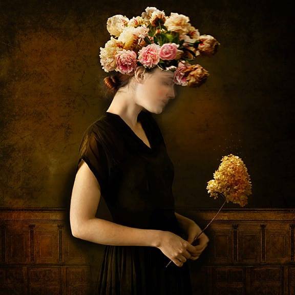 Tom Chambers Archival pigment print of a woman holding flowers, with flowers on her head looking down