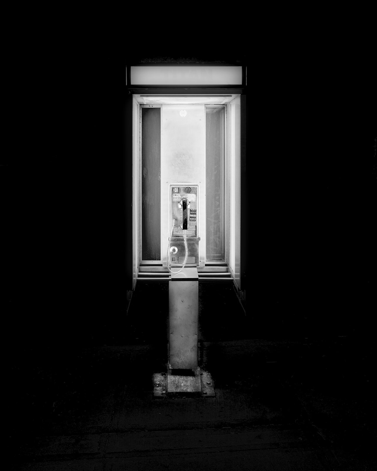 glowing nighttime phone booth photo by michael massaia