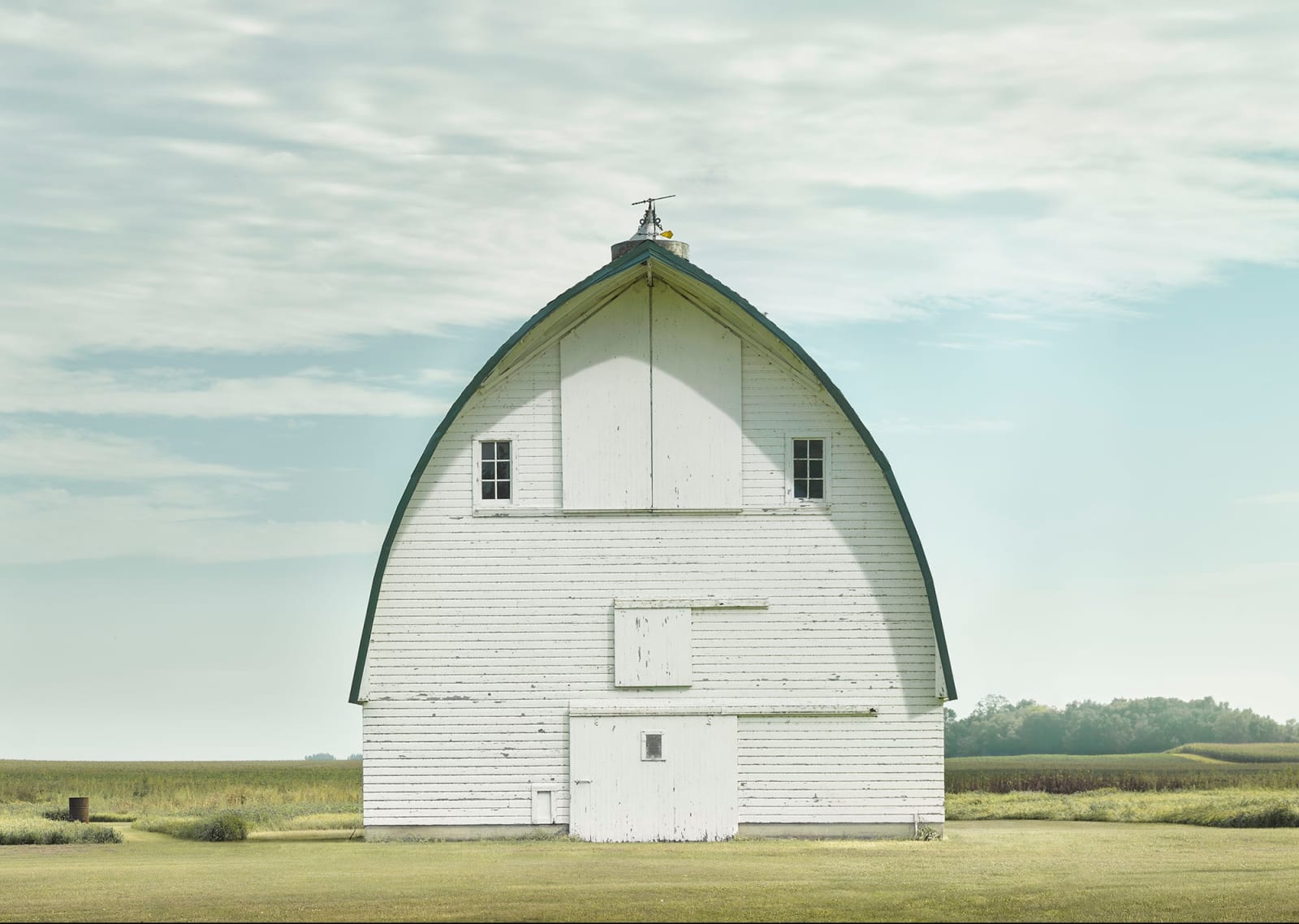 Jim Westphalen photograph of white barn in green field soft blue sky whispy clouds purchase at Gilman Contemporary