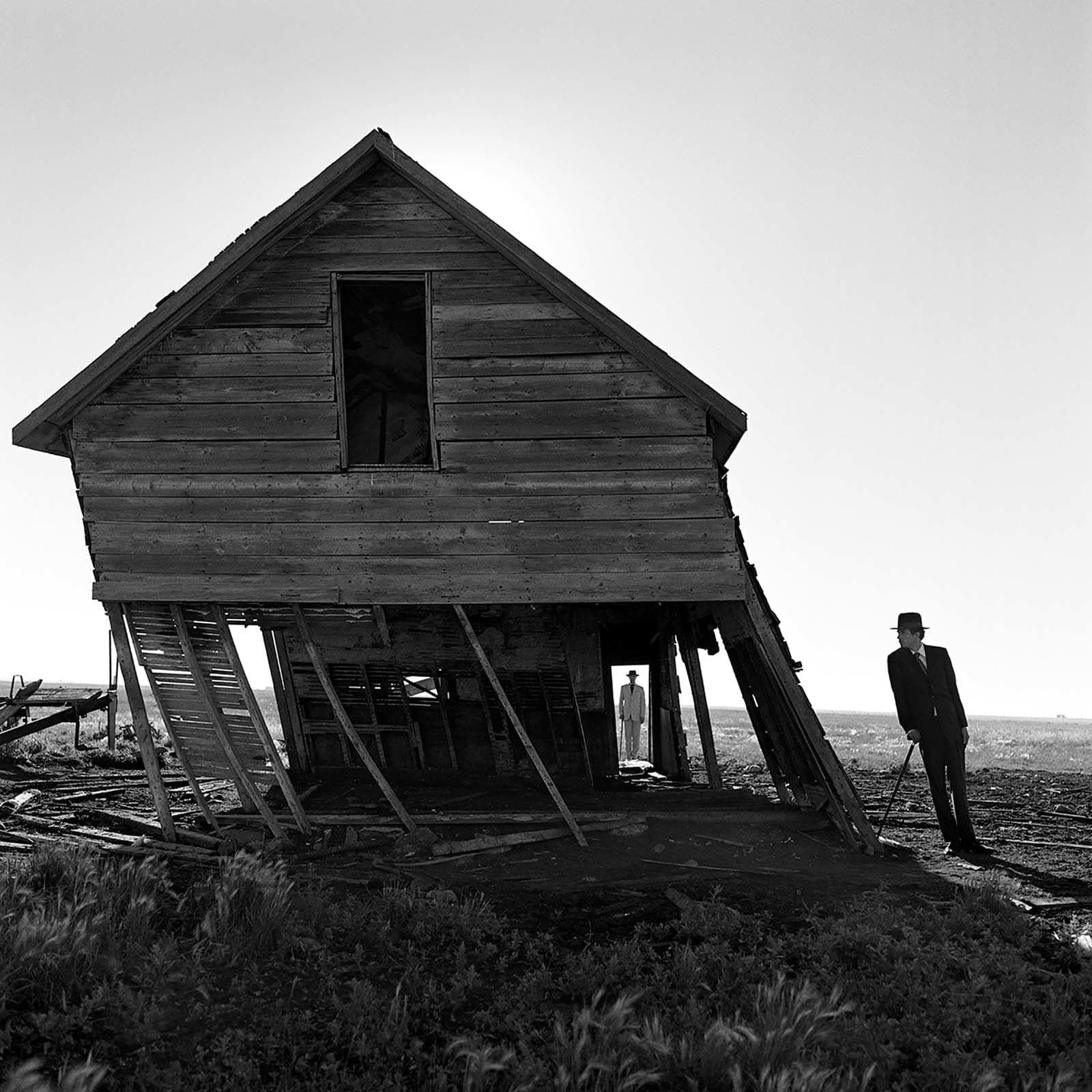 purchase Rodney Smith photography at Gilman Contemporary Sun Valley art gallery leaning house Alberta Canada leaning man