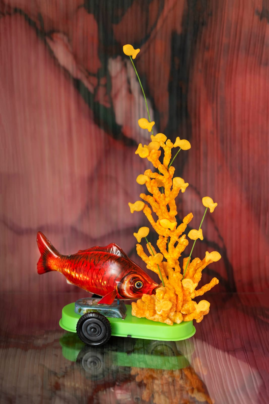 photo of toy fish on a boat with stacked goldfish on seaweed