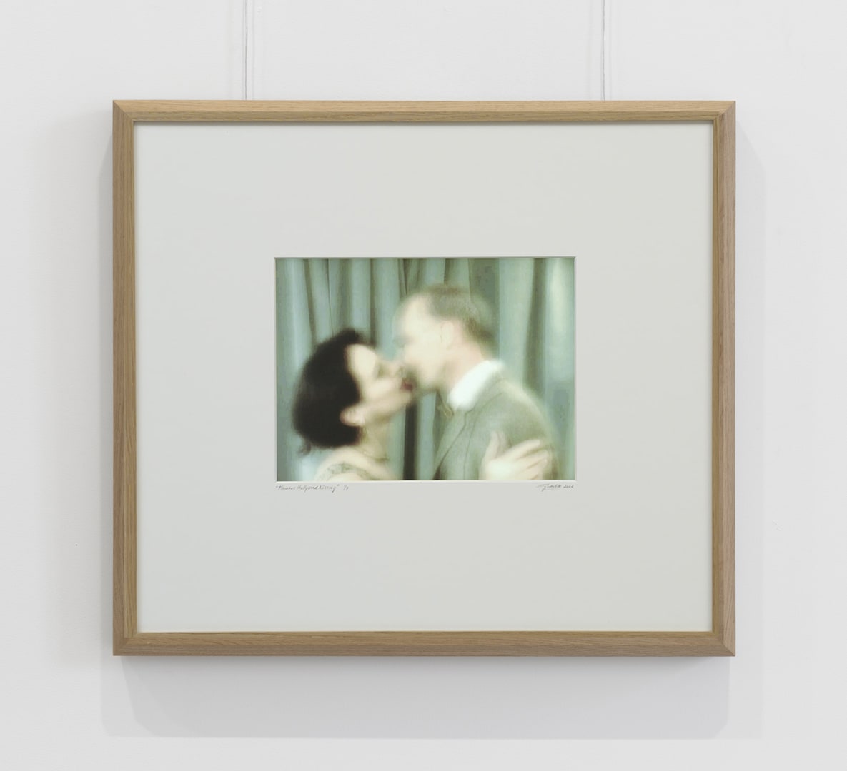 A framed photo of a couple kissing.