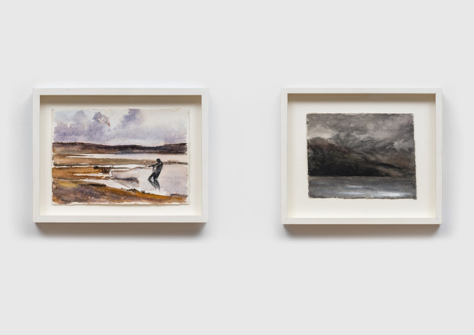 image depicts two framed watercolor and ink paintings. the painting on the left is of a man dragging a boat from the water, the painting on the right is of a dark landscape