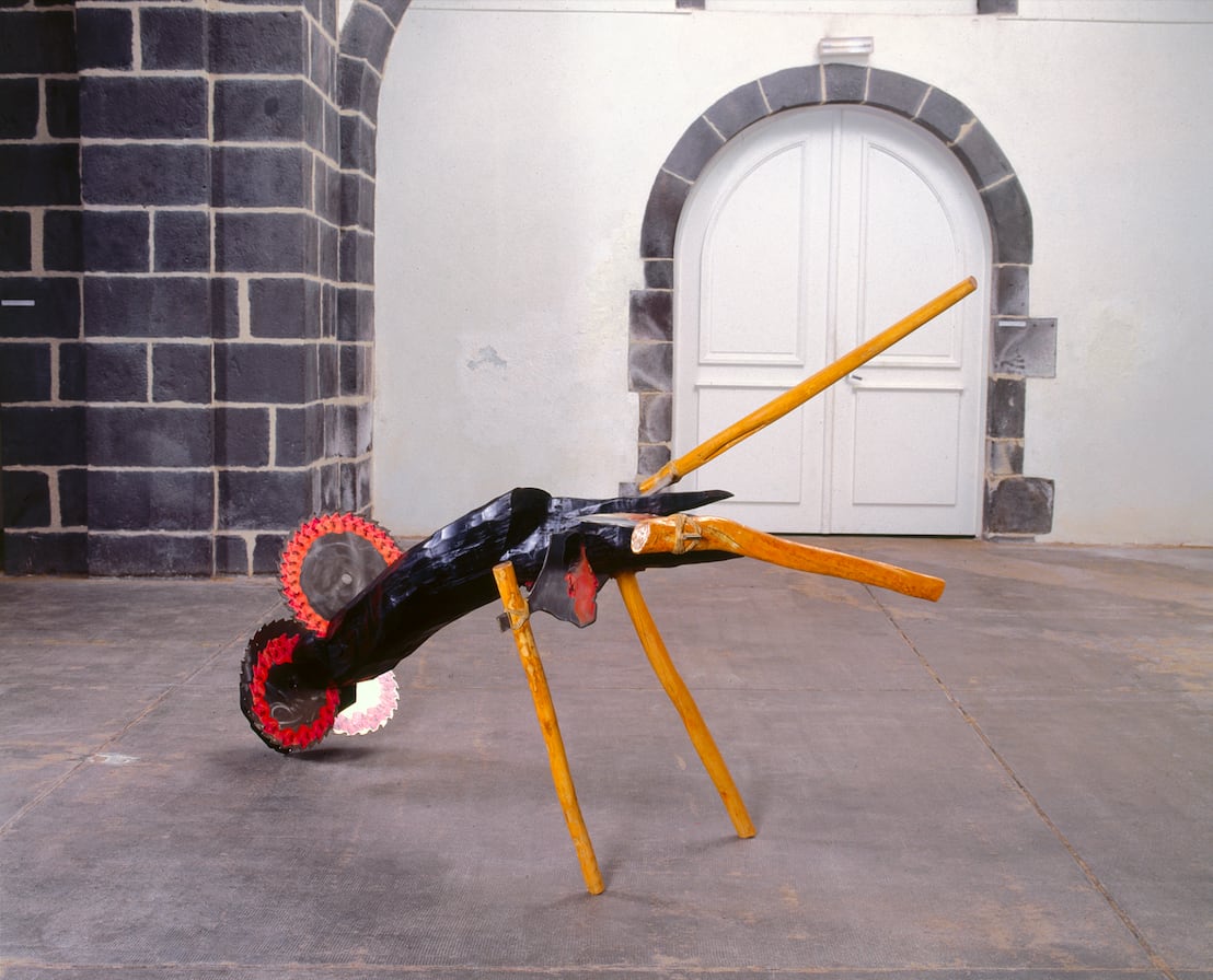 A mixed media sculpture with wooden legs.