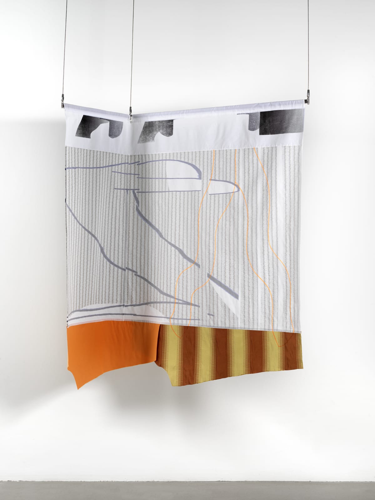 A gray-white, red, yellow and brown striped textile hanging against a white wall.