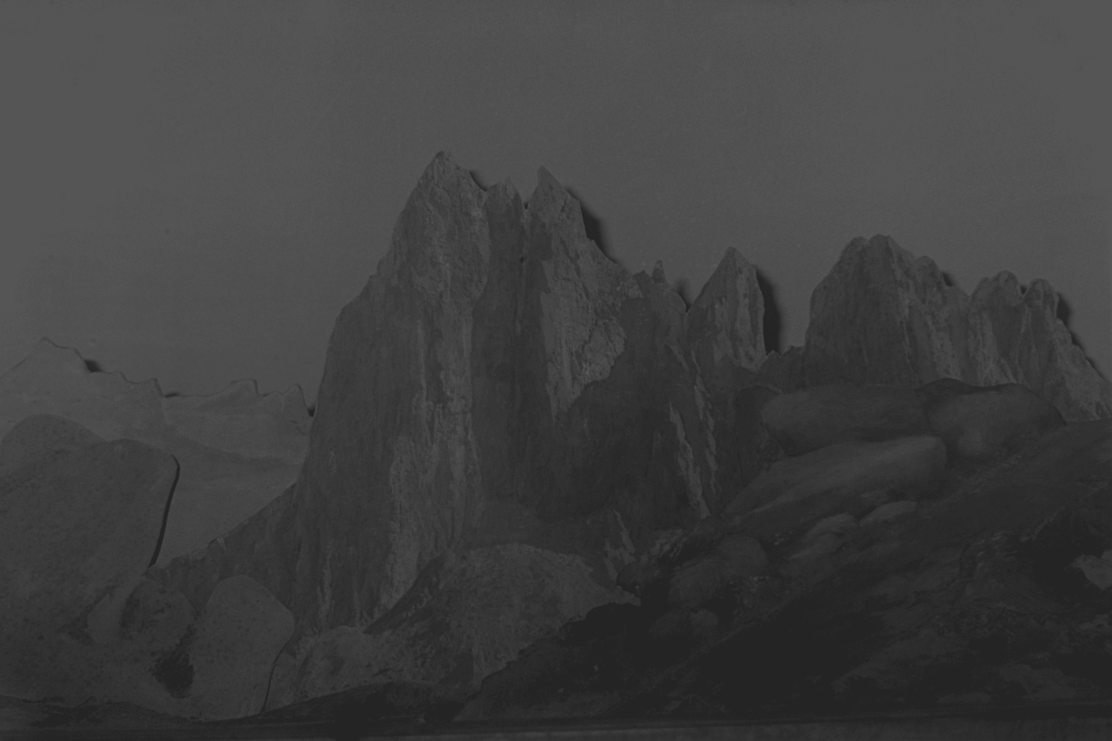 A black and white inkjet print of a mountain landscape.
