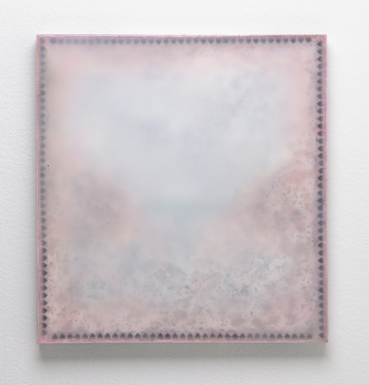 An image of a pink pigmented panel. made of rigid foam, rubber, and poppy seeds that frame the borders of the piece.