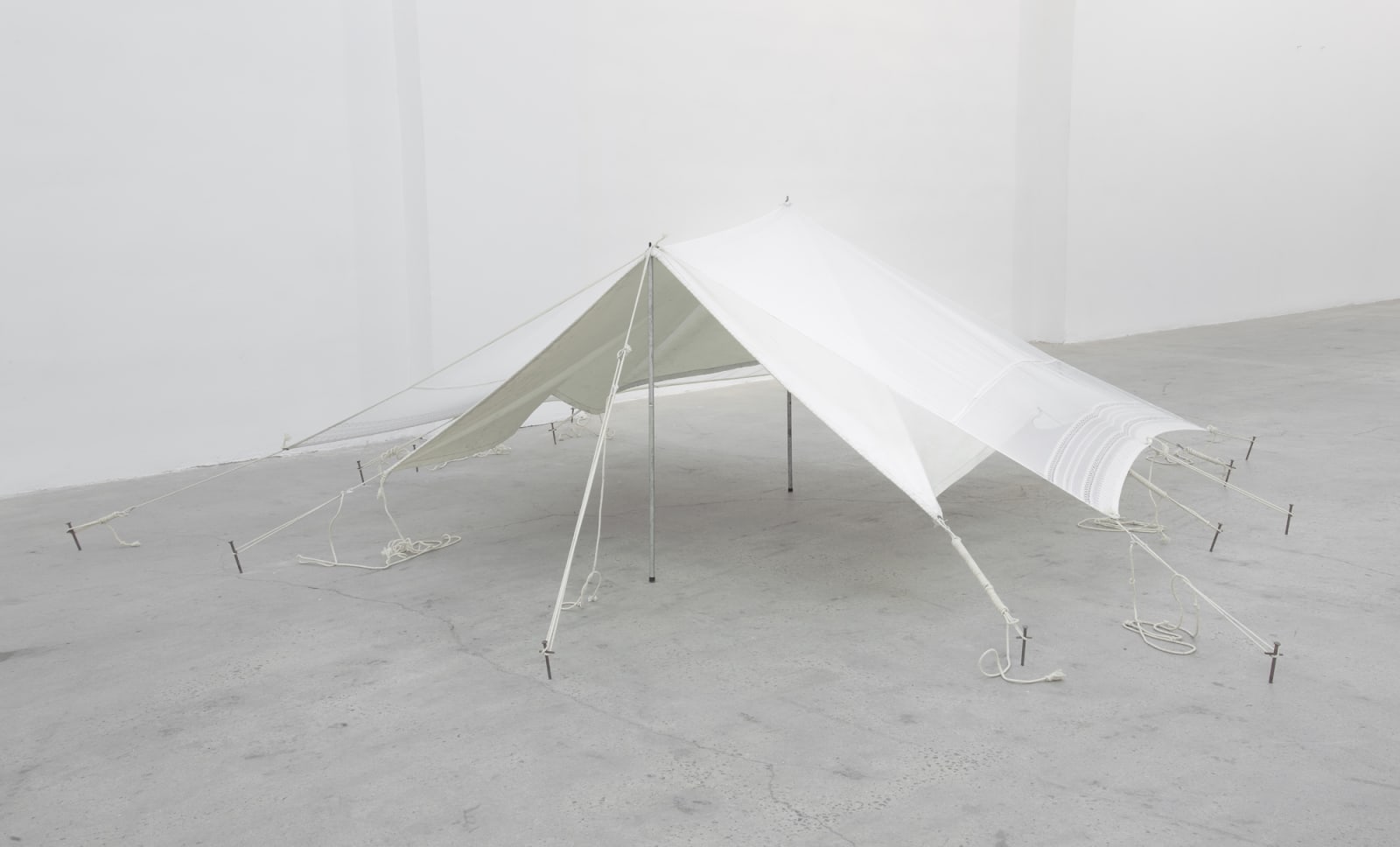 A sculpture of a tent set up in a gallery setting.
