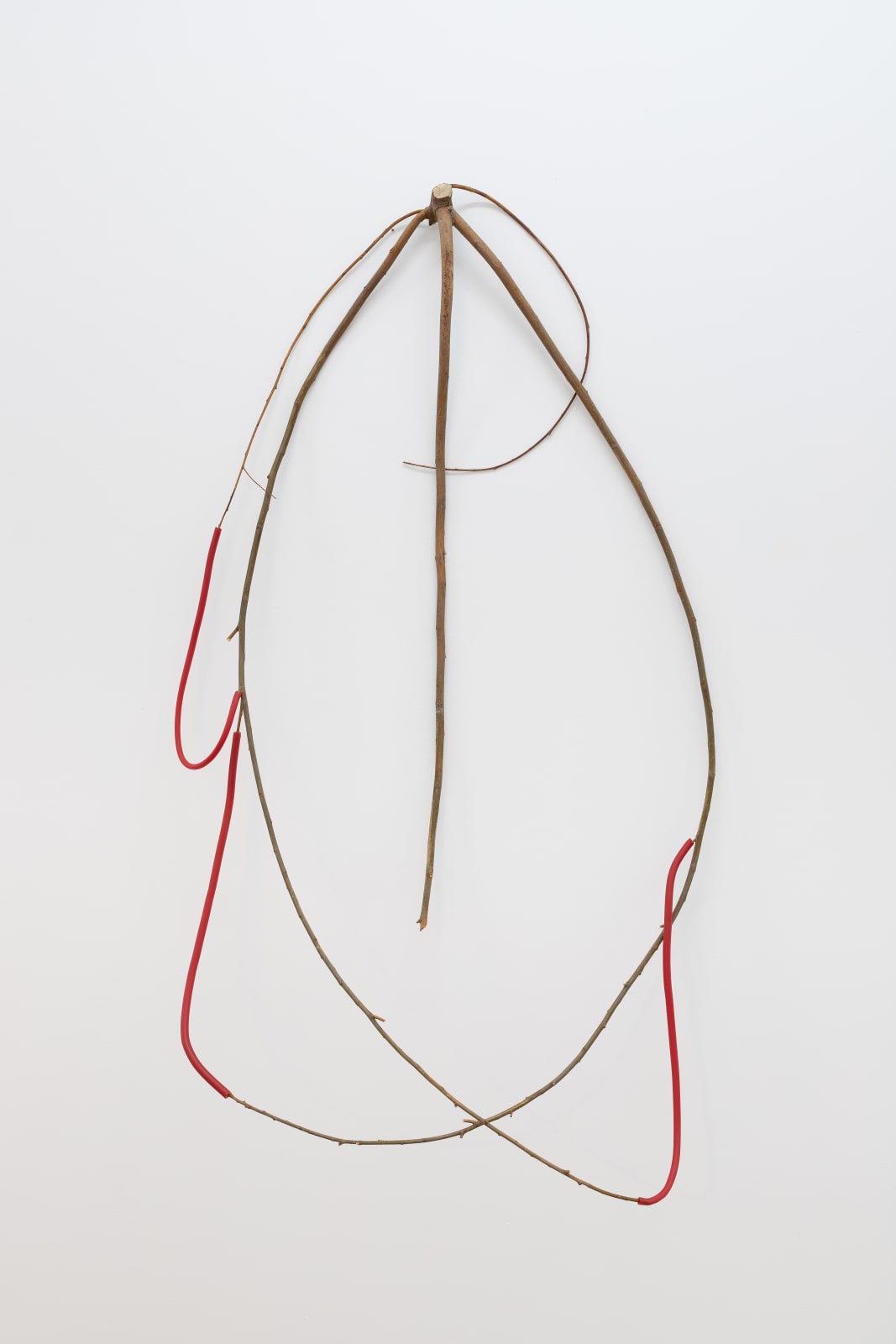 a spindly wall-mounted sculpture made of wood and wax