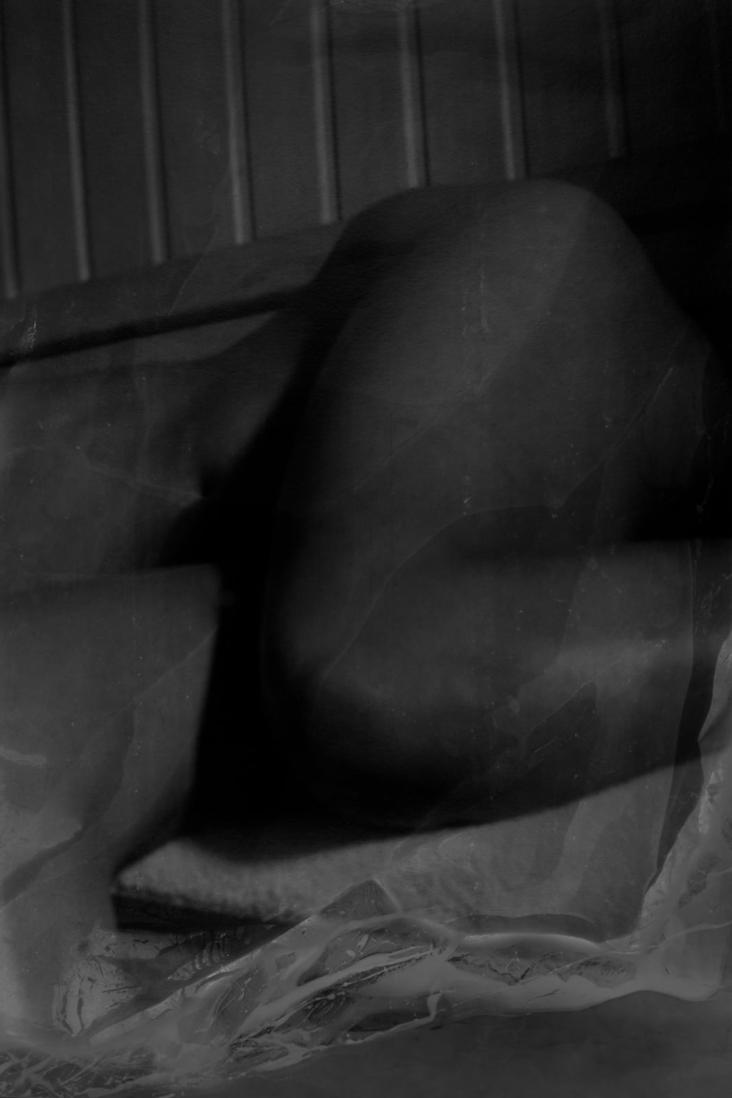 An inkjet print of a shadowy figure on a bed.