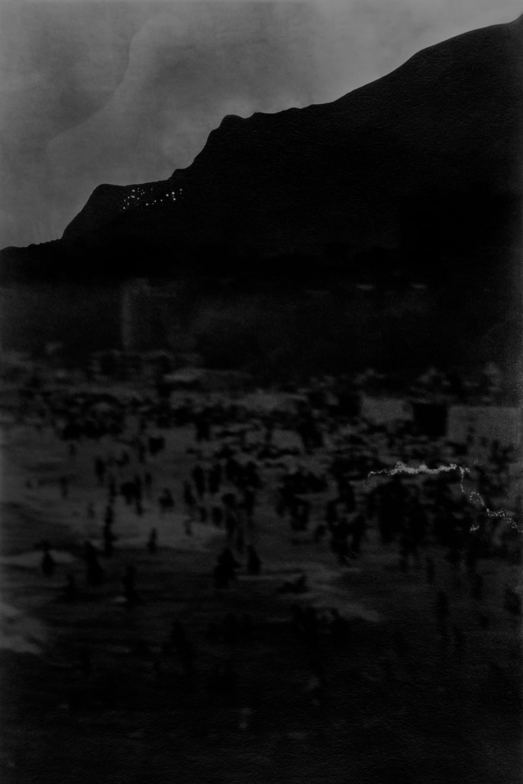 An inkjet print of a shadowy mountainous landscape.