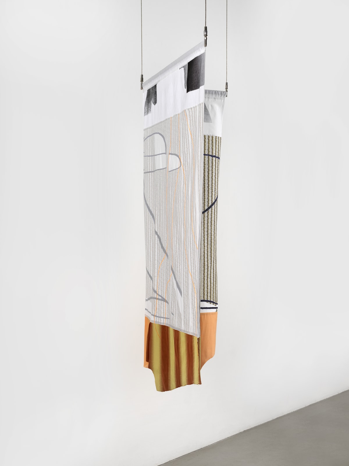 A gray-white, red, yellow and brown striped textile hanging against a white wall.