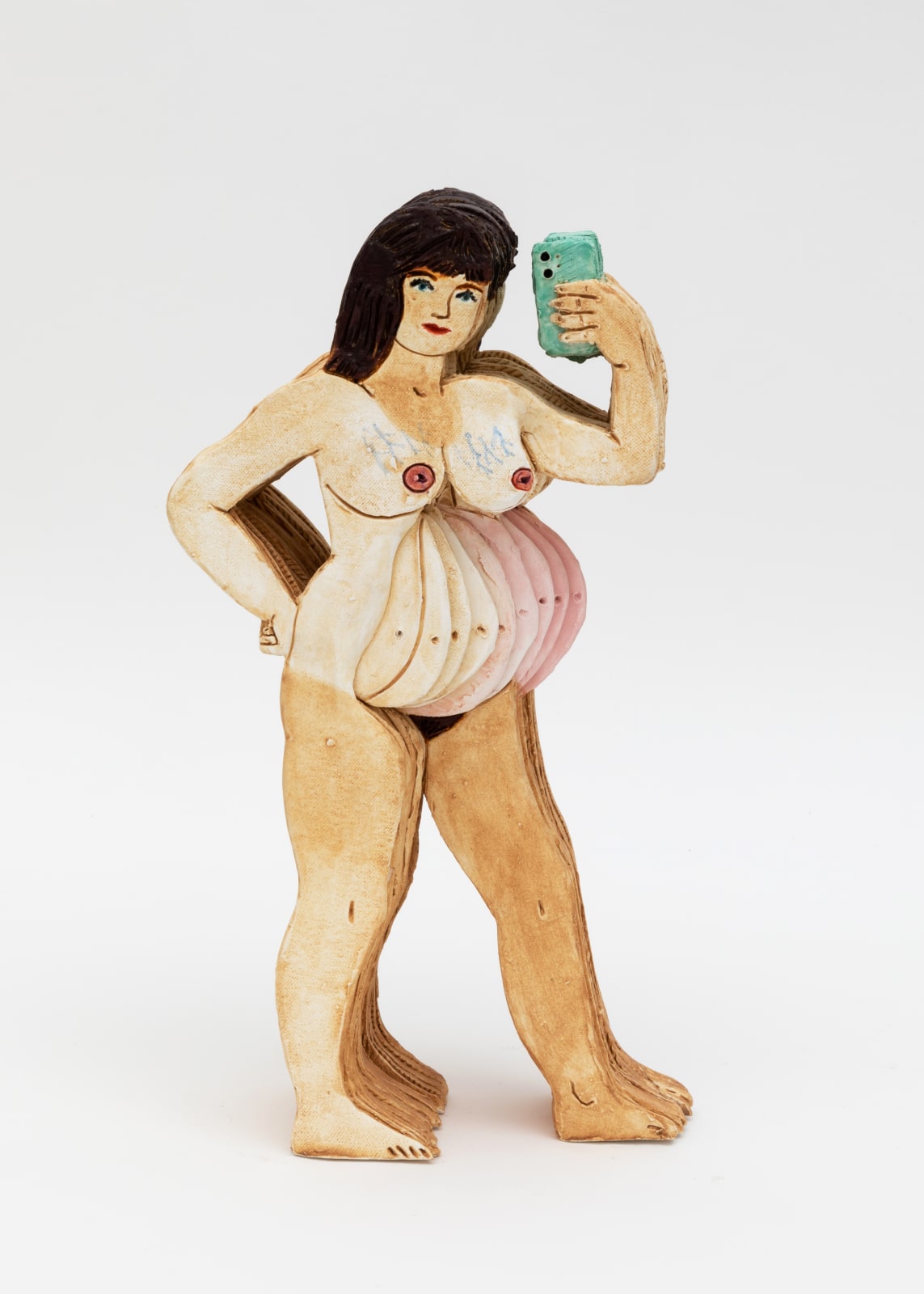 Ceramic sculpture of the artist naked and pregnant while holding her cell phone to take a selfie photo.  
