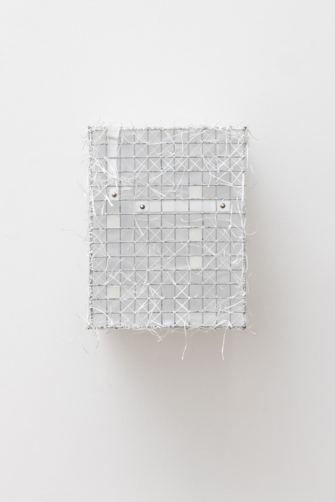 Wall-mounted sculpture of a wire rectangular care that is covered in white film, paper from receipts, envelopes, and dental floss