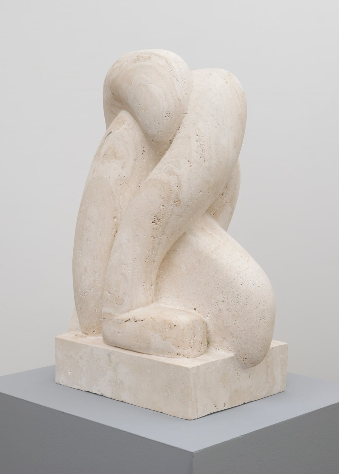 Free-standing marble sculpture of three bodily forms resembling limbs intertwining with each other making a braided shape on a marble square pedestal