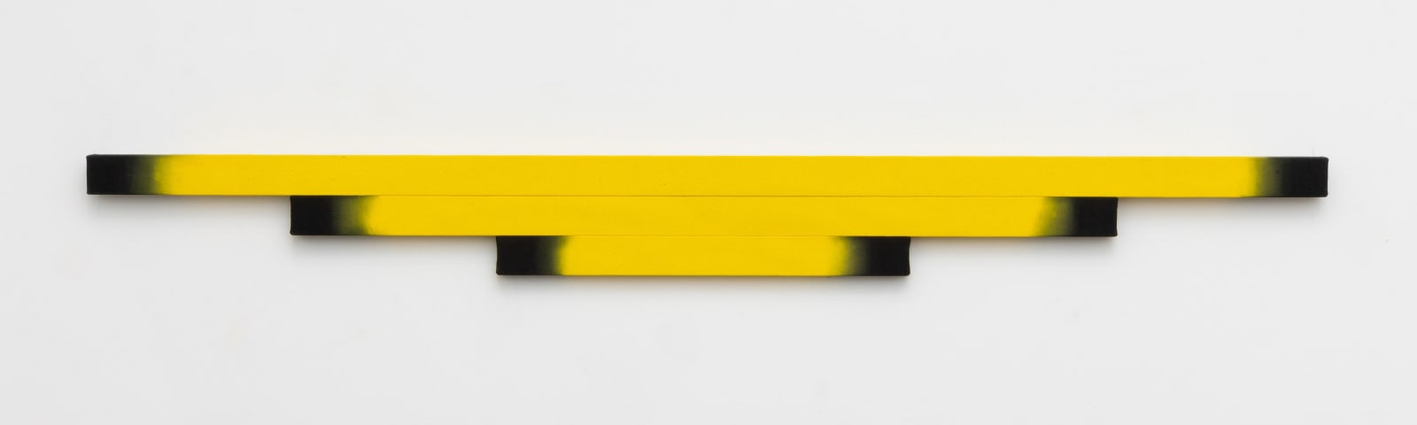 Horizontal shaped canvas painting stretched on three wooden bars varying in length and colors of yellow bleeding into black toward the edges.