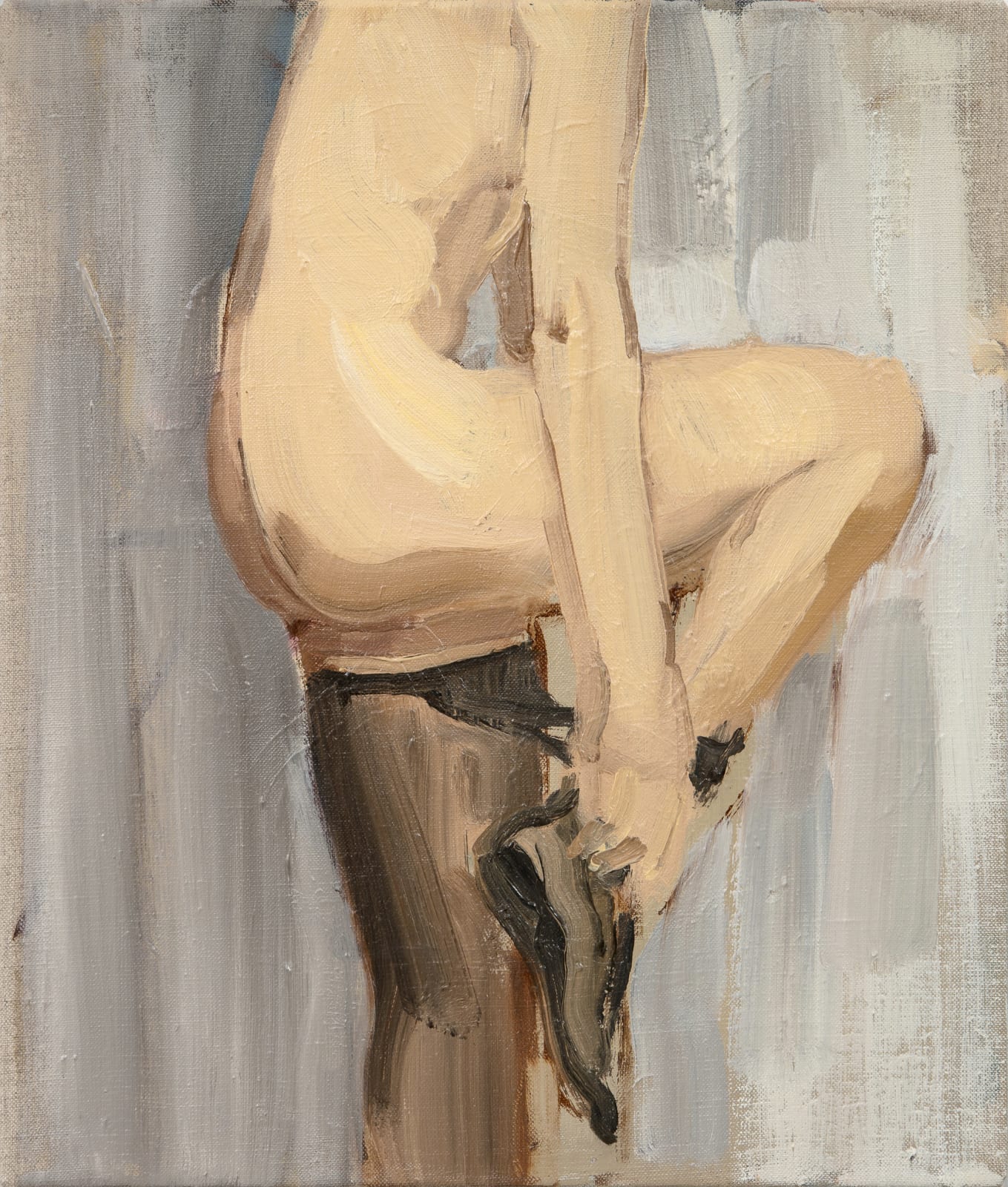 Woman contorts to pull stockings over her nude body in front of gray background. Her head is cropped out of the composition.