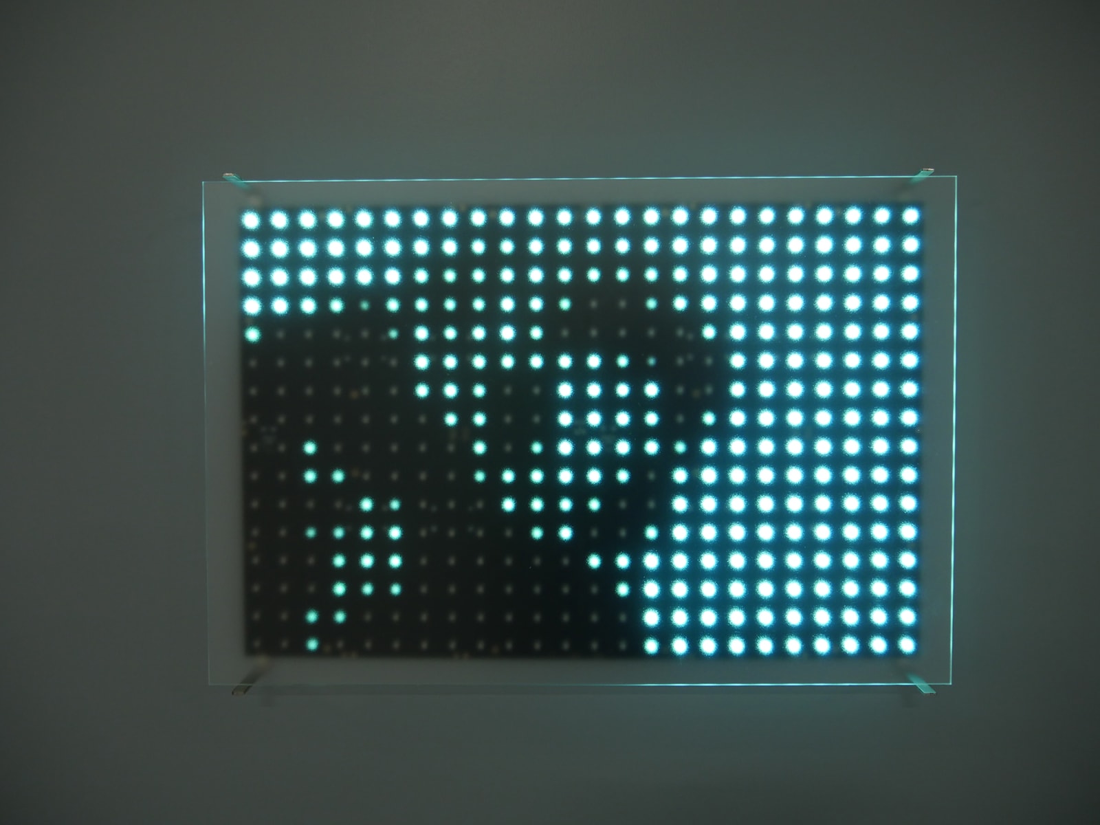 Close up of one of the nine LED panels that make up Rhythm Studies which displays a pixelated still image of a chimp