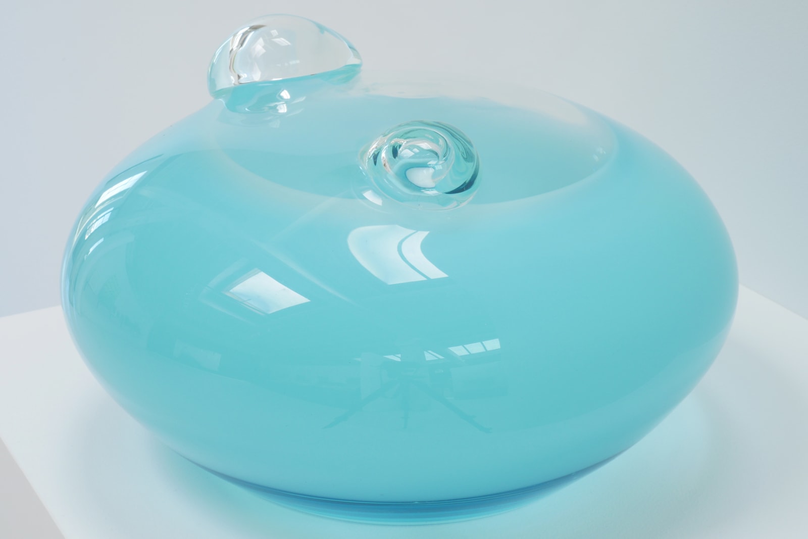 A light blue UFO-shaped sculpture with two clear bubbles on top.