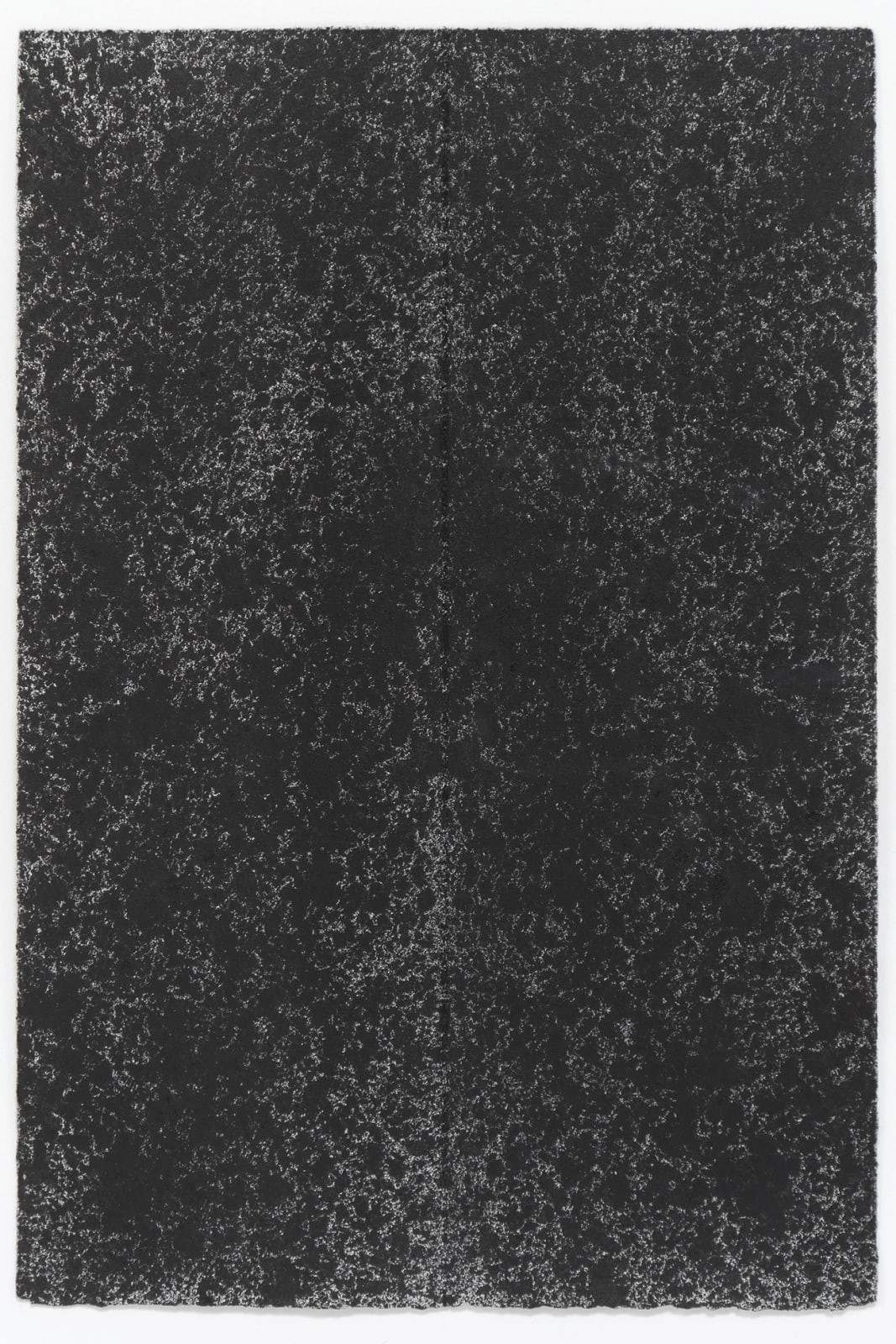Black ink on paper which was folded in half creates a dark blotchy scene that covers the entire paper with some negative space dotting through